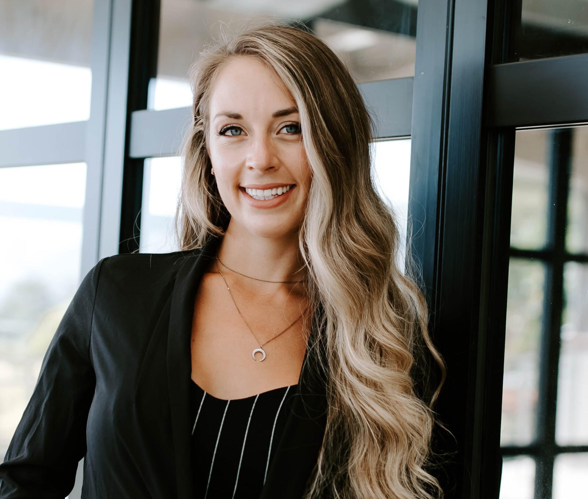 Smiling woman in black blazer.